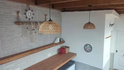 a table with chairs and a large umbrella at Apartamento Gitanilla in Chipiona