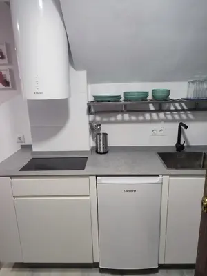 a small kitchen with white cabinets and a sink at Apartamento Gitanilla in Chipiona