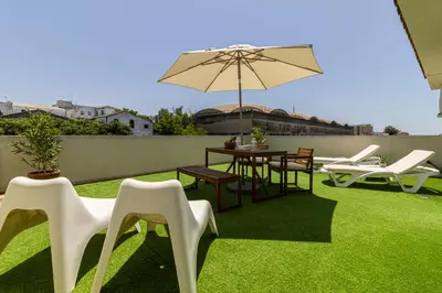 a patio with a table and chairs and an umbrella at Allo Apartments Arroyo Ático Parking Centro 1 Habitación in Jerez de la Frontera
