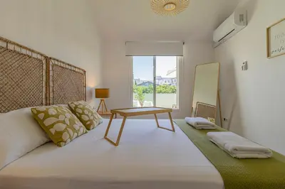 a bedroom with a large bed with a table on it at Allo Apartments Arroyo Ático Parking Centro 1 Habitación in Jerez de la Frontera