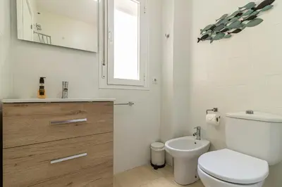 a white bathroom with a toilet and a sink at Allo Apartments Arroyo Ático Parking Centro 1 Habitación in Jerez de la Frontera