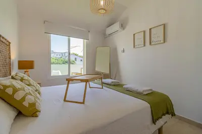 a bedroom with a bed with a table and a window at Allo Apartments Arroyo Ático Parking Centro 1 Habitación in Jerez de la Frontera