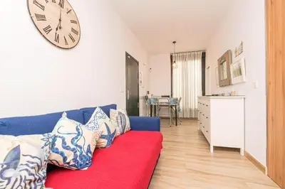 a kitchen with a red couch and a white refrigerator at Loving Rota in Rota