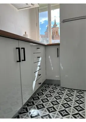 a kitchen with white cabinets and a black and white tile floor at Sherry-House & Parking in Jerez de la Frontera
