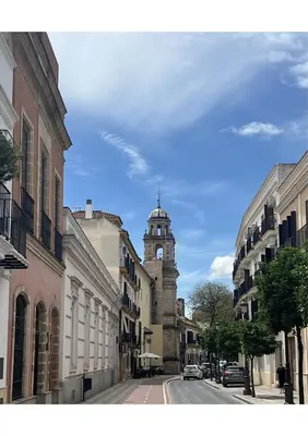 a city street with a clock tower in the distance at Sherry-House & Parking in Jerez de la Frontera