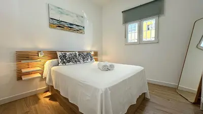 a bedroom with a bed with white sheets and a window at SIBS Sanlúcar Guadalquivir I - TERRAZA in Sanlúcar de Barrameda