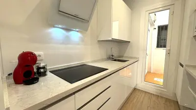 a white kitchen with a red appliance on a counter at SIBS Sanlúcar Guadalquivir I - TERRAZA in Sanlúcar de Barrameda