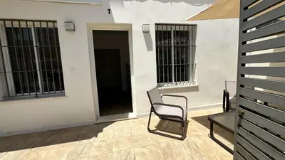 a chair sitting on a patio next to a building at SIBS Sanlúcar Guadalquivir I - TERRAZA in Sanlúcar de Barrameda