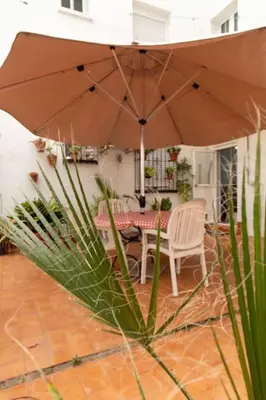 a patio with a table and an umbrella at El Patio de la Viña by Gades Gestión in Cádiz