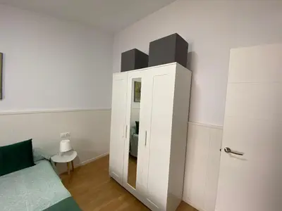 a bedroom with a white cabinet with a mirror at TU ESCONDITE in Jerez de la Frontera
