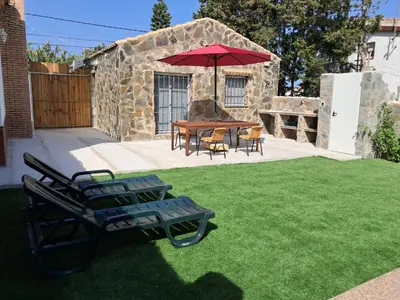 a patio with a table and chairs and an umbrella at Casita café in Chiclana de la Frontera