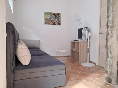 a living room with a couch and a tv at Casita café in Chiclana de la Frontera