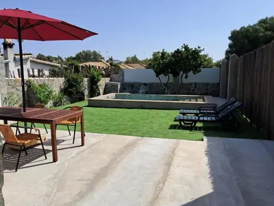 a backyard with a table and chairs and a pool at Casita café in Chiclana de la Frontera