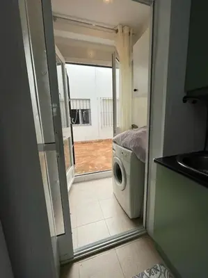 a door to a room with a washing machine at Apartamento ZIUREV IV in Sanlúcar de Barrameda