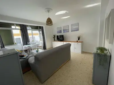 a living room with a couch and a table at Apartamento ZIUREV IV in Sanlúcar de Barrameda