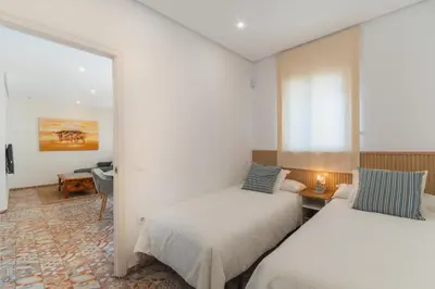 two beds in a room with a mirror at Manolete apartamento in Jerez de la Frontera