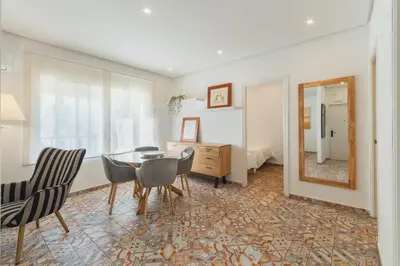 a dining room with a table and chairs and a mirror at Manolete apartamento in Jerez de la Frontera