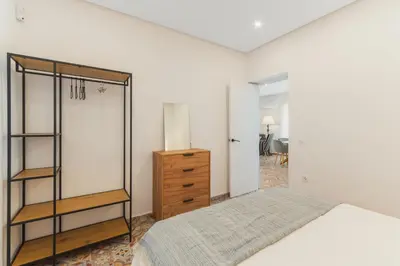 a bedroom with a bed and a wooden dresser at Manolete apartamento in Jerez de la Frontera