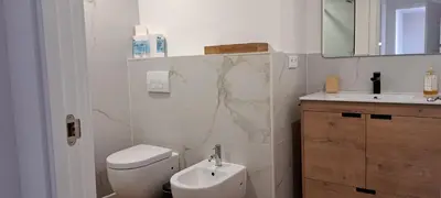 a bathroom with a toilet and a sink and a mirror at Villa Marcel in Jerez de la Frontera