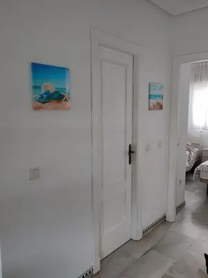 a white door in a room with a bedroom at Apartamento Pinar del Atlántico La Barrosa in Chiclana de la Frontera