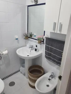 a white bathroom with a sink and a toilet at Apartamento Pinar del Atlántico La Barrosa in Chiclana de la Frontera