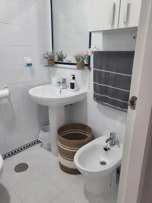 a white bathroom with a sink and a toilet at Apartamento Pinar del Atlántico La Barrosa in Chiclana de la Frontera
