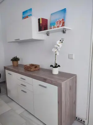 a kitchen with white cabinets and a wooden counter top at Apartamento Pinar del Atlántico La Barrosa in Chiclana de la Frontera