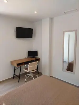 a bedroom with a desk and a computer on a wall at Villa caracolillo PLAYA Chiclana in Chiclana de la Frontera