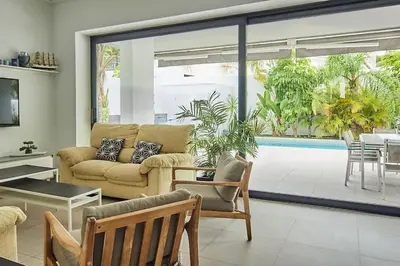 a living room with a couch and a table at Villa caracolillo PLAYA Chiclana in Chiclana de la Frontera