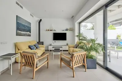 a living room with a couch and a tv at Villa caracolillo PLAYA Chiclana in Chiclana de la Frontera