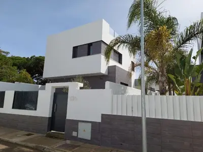 a white house with a fence and a door at VILLA caracolillo MAR in Chiclana de la Frontera