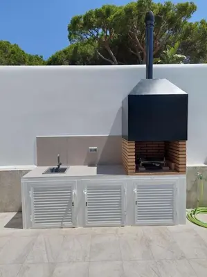 a outdoor kitchen with a fireplace in a backyard at VILLA caracolillo MAR in Chiclana de la Frontera