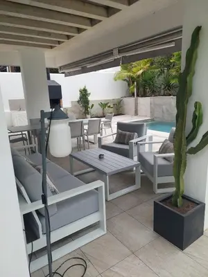 a patio with couches and a table and a cactus at VILLA caracolillo MAR in Chiclana de la Frontera