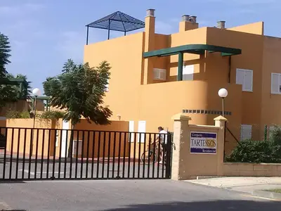 a large yellow building with a black fence at Casa Tartessos in Costa Ballena