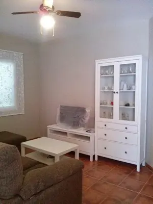 a living room with a white cabinet and a table at Casa Tartessos in Costa Ballena