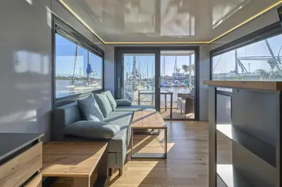 a living room with a couch and some windows at The Boathouse Company - Casa flotante experience - Real Club Náutico, El Puerto de Santa María in El Puerto de Santa María