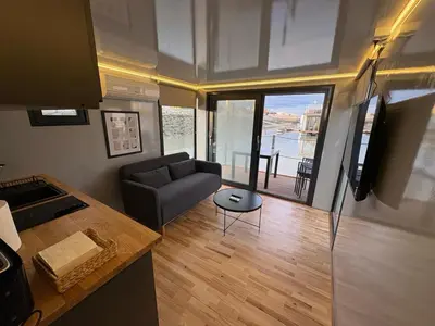a living room with a couch and a table at The Boathouse Company - Casa flotante experience - Real Club Náutico, El Puerto de Santa María in El Puerto de Santa María