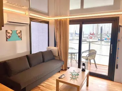 a living room with a couch and a table at The Boathouse Company - Casa flotante experience - Real Club Náutico, El Puerto de Santa María in El Puerto de Santa María
