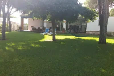 a yard with two lawn chairs and a hose at Chalet en Roche - Amplio jardín in Roche