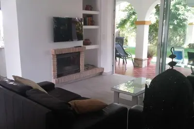 a living room with a couch and a fireplace at Chalet en Roche - Amplio jardín in Roche