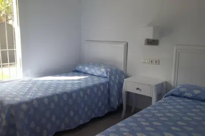 a bedroom with two beds and a table and a window at Chalet en Roche - Amplio jardín in Roche
