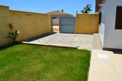 a backyard with a fence and green grass at CHALET SOLYMAR in Conil de la Frontera