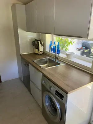 a kitchen with a sink and a washing machine at Villa America in Roche