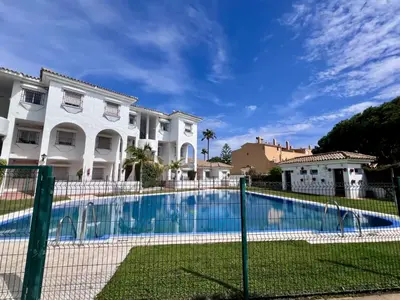 a swimming pool in front of a house at Apartamento Empul Costa Sancti Petri in Chiclana de la Frontera