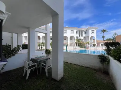a patio with a table and chairs in front of a house at Apartamento Empul Costa Sancti Petri in Chiclana de la Frontera