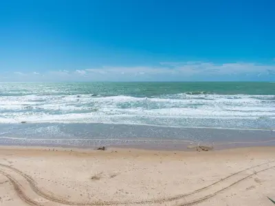 a sandy beach with waves in the ocean at Holiday Home in Cadiz by the Sea in Cádiz
