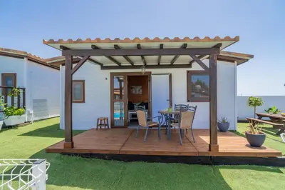 a patio with a table and chairs on a deck at El Paraíso Perdido in Conil de la Frontera