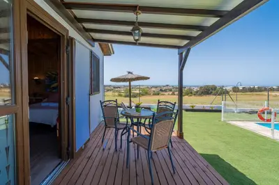 a patio with a table and chairs on a deck at El Paraíso Perdido in Conil de la Frontera
