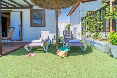 a patio with chairs and flip flops on the grass at El Paraíso Perdido in Conil de la Frontera