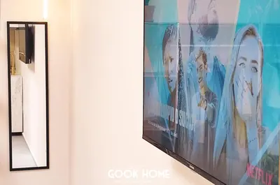 a television hanging on a wall next to a mirror at LalaSuites ARENAL in Jerez de la Frontera